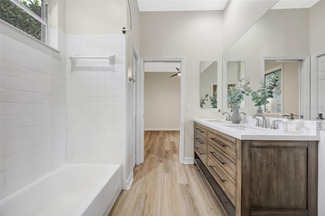 5103 Twin Creeks Dr, Valrico, FL 33596 - bathroom featuring plenty of natural light, wood finished floors, double vanity, and bathing tub / shower combination