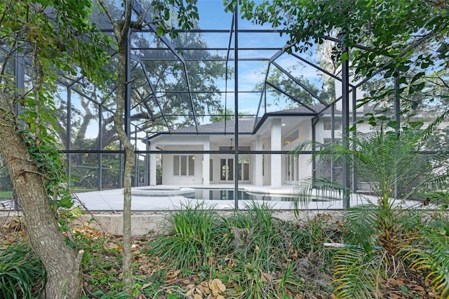 5103 Twin Creeks Dr, Valrico, FL 33596 - rear view of property featuring glass enclosure, a patio, an in-ground hot tub, and an outdoor pool
