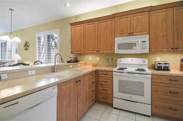 8579 54th Avenue Cir E, Bradenton, FL 34211 - kitchen with white appliances, light countertops, brown cabinetry, and recessed lighting
