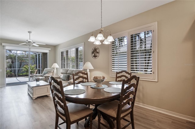8579 54th Avenue Cir E, Bradenton, FL 34211 - dining area with wood finished floors, a chandelier, and ceiling fan