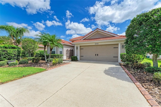 8906 Stone Harbour Loop, Bradenton, FL 34212 - mediterranean / spanish home with stucco siding, driveway, a garage, and a tiled roof