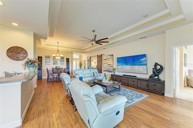 8906 Stone Harbour Loop, Bradenton, FL 34212 - living area with a raised ceiling, a chandelier, light wood-style floors, crown molding, and ceiling fan