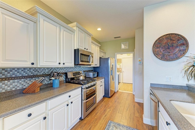 8906 Stone Harbour Loop, Bradenton, FL 34212 - kitchen with appliances with stainless steel finishes, light wood-style flooring, decorative backsplash, white cabinetry, and recessed lighting