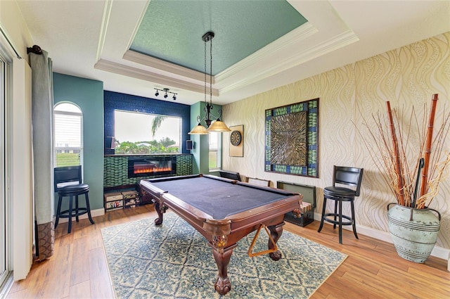 8906 Stone Harbour Loop, Bradenton, FL 34212 - playroom featuring a raised ceiling, crown molding, a glass covered fireplace, pool table, and wood finished floors