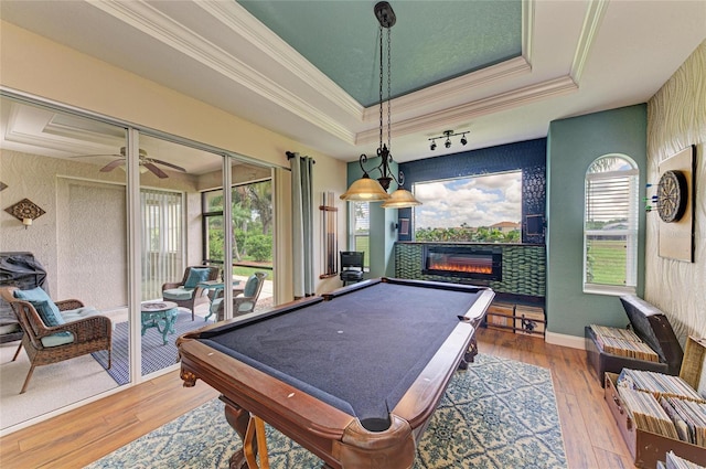 8906 Stone Harbour Loop, Bradenton, FL 34212 - game room featuring pool table, ornamental molding, hardwood / wood-style floors, a tiled fireplace, and a raised ceiling