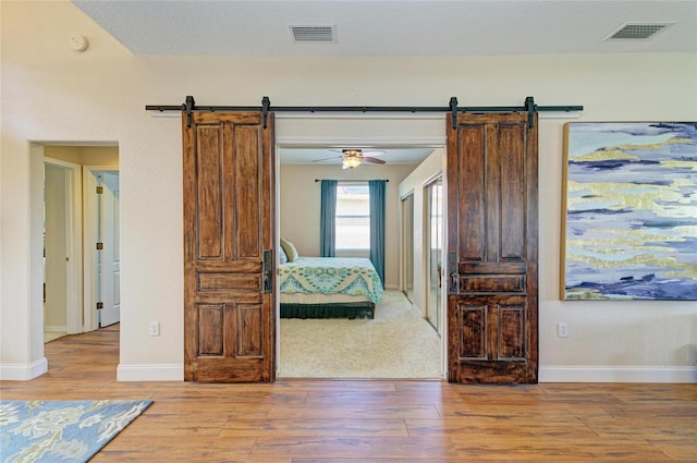 8906 Stone Harbour Loop, Bradenton, FL 34212 - bedroom with a barn door and light wood-type flooring