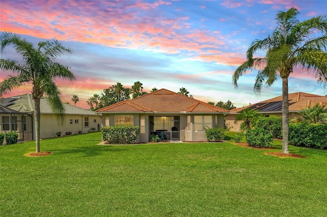 8906 Stone Harbour Loop, Bradenton, FL 34212 - rear view of house with a lawn, a tiled roof, and stucco siding