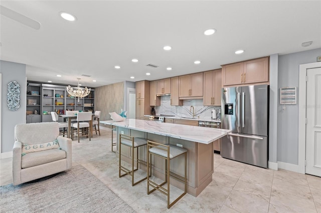 5806 Gulf Dr Unit 201S, Holmes Beach, FL 34217 - kitchen featuring stainless steel appliances, a chandelier, recessed lighting, a kitchen bar, and light stone countertops