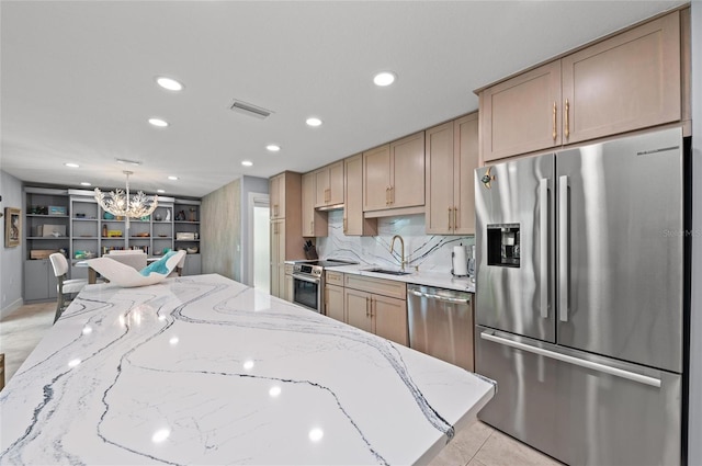 5806 Gulf Dr Unit 201S, Holmes Beach, FL 34217 - kitchen with appliances with stainless steel finishes, a chandelier, light stone counters, recessed lighting, and tasteful backsplash