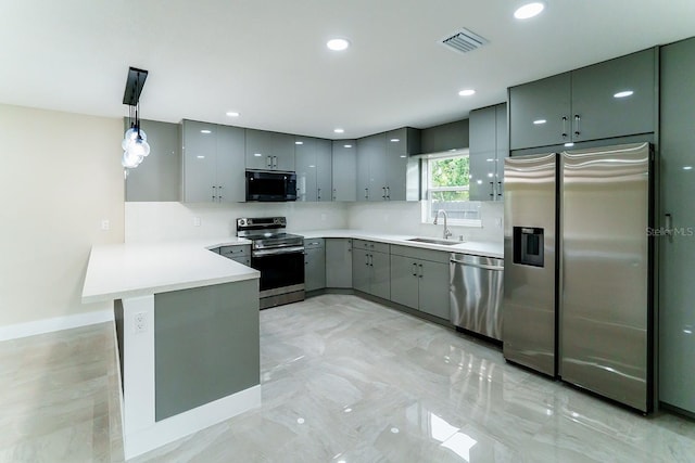 4616 34th Ave E, Bradenton, FL 34208 - kitchen with stainless steel appliances, gray cabinetry, a peninsula, pendant lighting, and light countertops