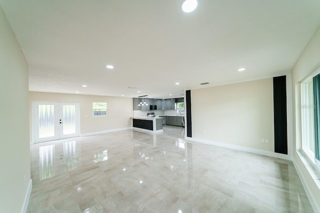 4616 34th Ave E, Bradenton, FL 34208 - unfurnished living room with light marble finish floors, recessed lighting, and french doors