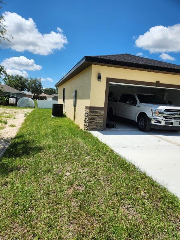 13074 SW 104th Ln, Dunnellon, FL 34432 - view of property exterior with driveway, stucco siding, central AC, stone siding, and a yard