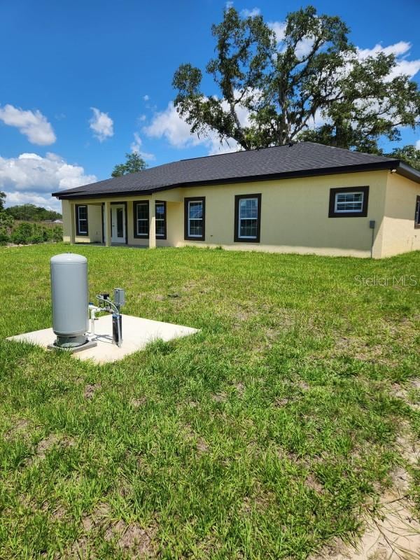 13074 SW 104th Ln, Dunnellon, FL 34432 - rear view of house featuring stucco siding and a lawn