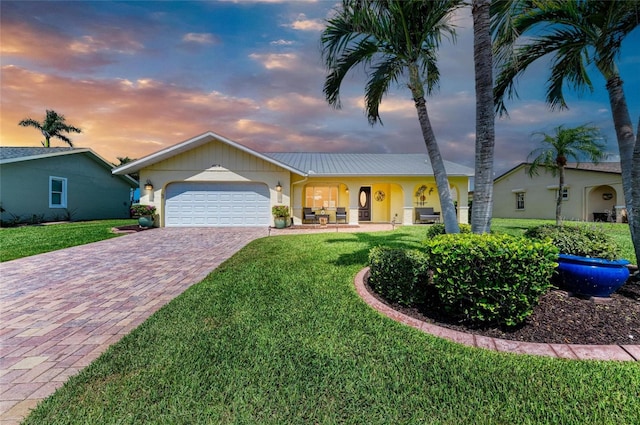 4508 Mangrove Point Rd, Bradenton, FL 34210 - ranch-style house with an attached garage, decorative driveway, a yard, and stucco siding
