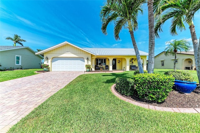 4508 Mangrove Point Rd, Bradenton, FL 34210 - ranch-style house with an attached garage, driveway, a front lawn, and stucco siding