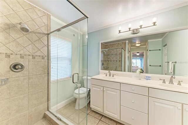 4508 Mangrove Point Rd, Bradenton, FL 34210 - bathroom featuring a stall shower, double vanity, crown molding, tile patterned floors, and toilet