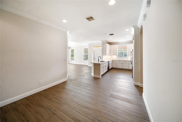 7403 Hamilton Rd, Bradenton, FL 34209 - unfurnished living room featuring a sink, crown molding, baseboards, wood finished floors, and recessed lighting