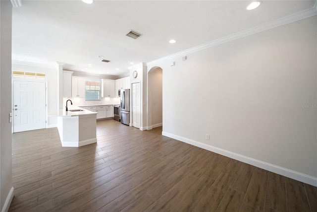 7403 Hamilton Rd, Bradenton, FL 34209 - kitchen featuring open floor plan, ornamental molding, light countertops, white cabinets, and wood finished floors