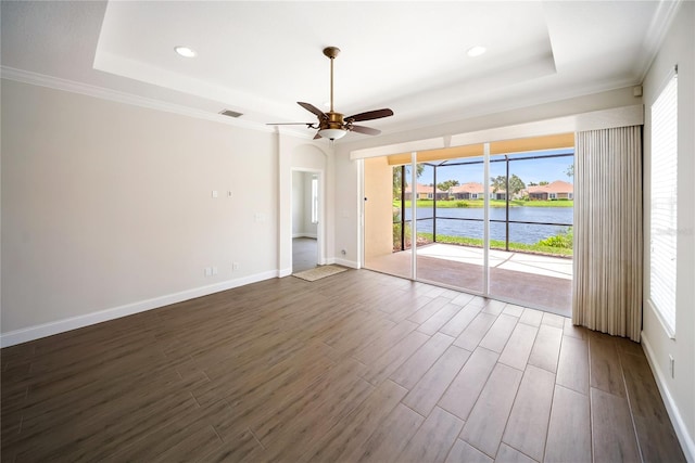 7403 Hamilton Rd, Bradenton, FL 34209 - spare room featuring a raised ceiling, a water view, dark wood finished floors, plenty of natural light, and crown molding