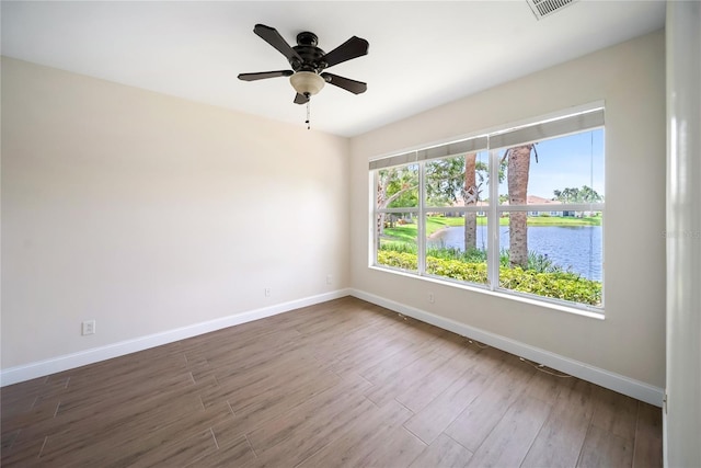 7403 Hamilton Rd, Bradenton, FL 34209 - spare room with baseboards, wood finished floors, ceiling fan, and a water view