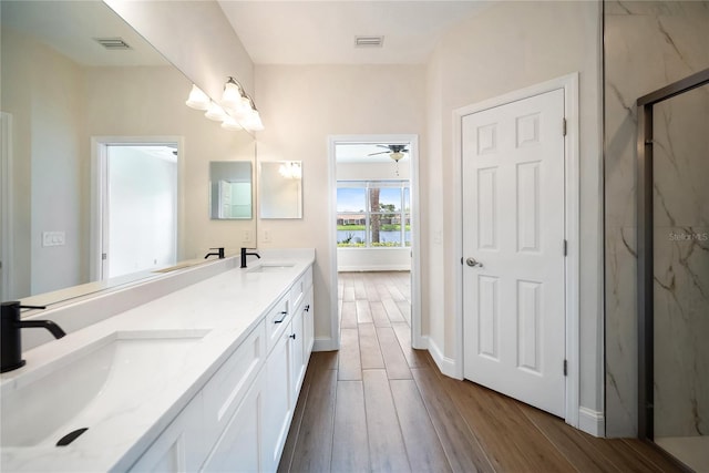 7403 Hamilton Rd, Bradenton, FL 34209 - bathroom featuring a marble finish shower, wood finished floors, double vanity, and baseboards