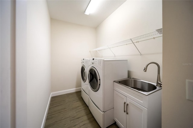 7403 Hamilton Rd, Bradenton, FL 34209 - washroom featuring washing machine and dryer, baseboards, wood finished floors, and cabinet space