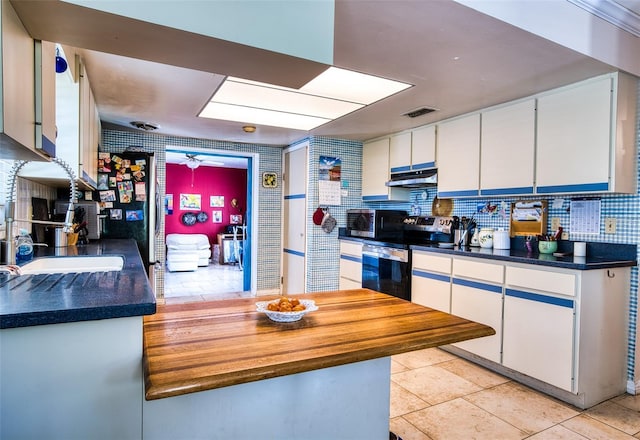 2216 Lake Shore Dr, Nokomis, FL 34275 - kitchen featuring appliances with stainless steel finishes, under cabinet range hood, white cabinets, backsplash, and dark countertops