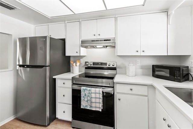 643 Park Cir, Bradenton, FL 34207 - kitchen with extractor fan, appliances with stainless steel finishes, light countertops, and white cabinetry