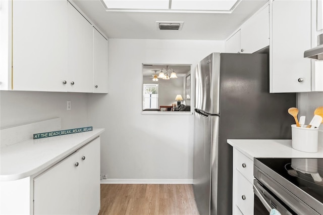 643 Park Cir, Bradenton, FL 34207 - kitchen featuring light wood-style flooring, a chandelier, light countertops, and white cabinetry