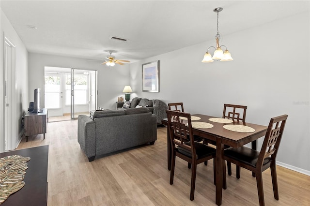 643 Park Cir, Bradenton, FL 34207 - dining space with light wood-style flooring, a ceiling fan, and a chandelier