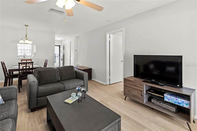 643 Park Cir, Bradenton, FL 34207 - living room with light wood-style flooring, ceiling fan, a textured ceiling, and a chandelier