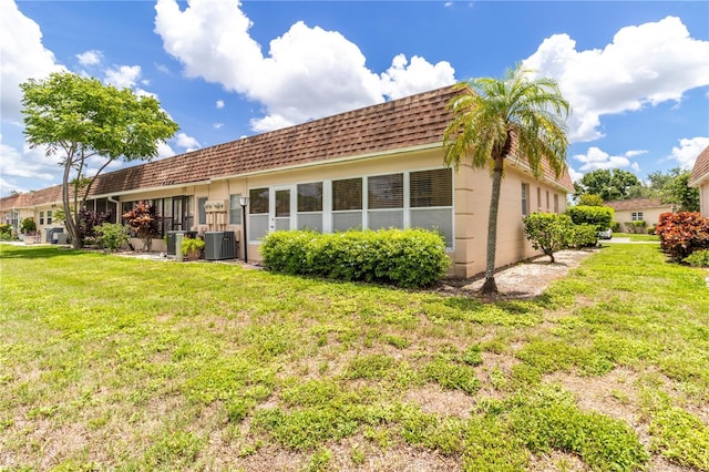 643 Park Cir, Bradenton, FL 34207 - rear view of house with a yard, roof with shingles, and mansard roof