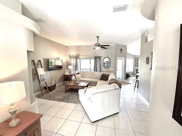 11315 Cypress Shore Ct, Clermont, FL 34711 - living area with light tile patterned flooring, a ceiling fan, and baseboards