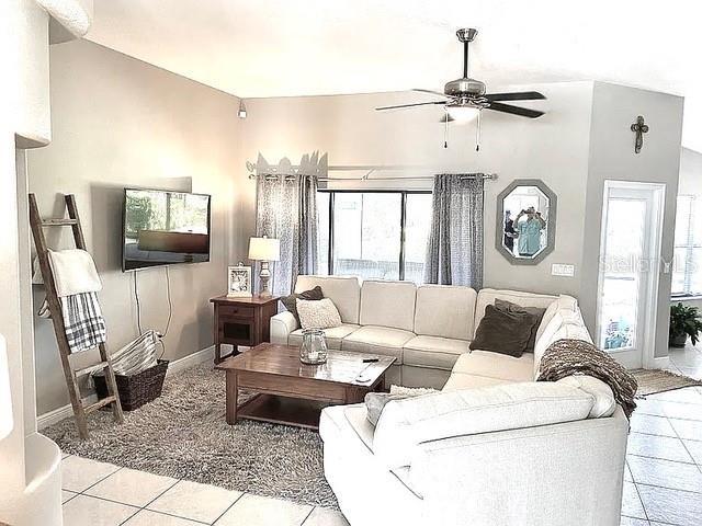 11315 Cypress Shore Ct, Clermont, FL 34711 - living area with ceiling fan, plenty of natural light, light tile patterned floors, and baseboards