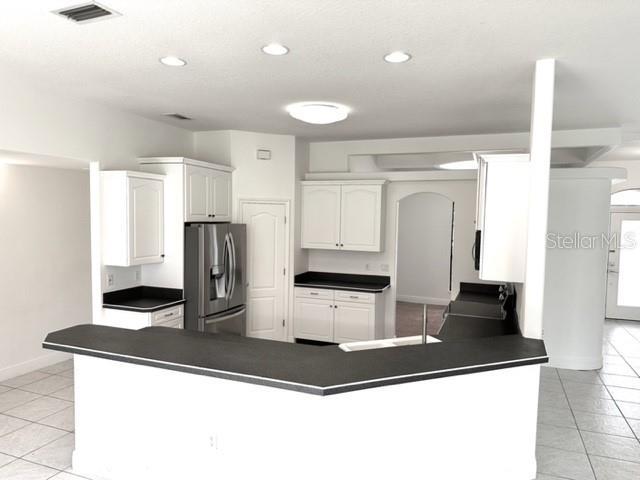 11315 Cypress Shore Ct, Clermont, FL 34711 - kitchen featuring appliances with stainless steel finishes, dark countertops, a peninsula, and recessed lighting