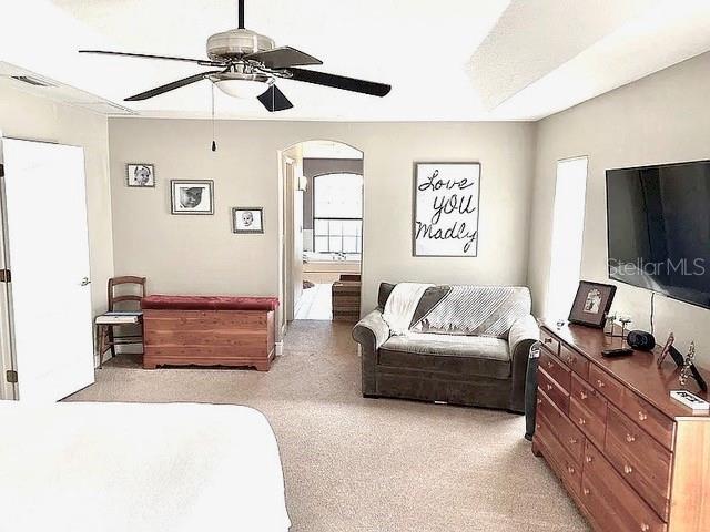 11315 Cypress Shore Ct, Clermont, FL 34711 - bedroom with arched walkways, a ceiling fan, and ensuite bathroom