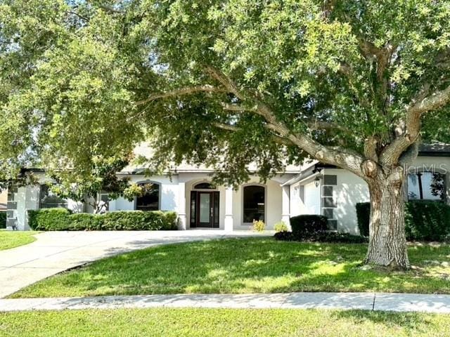 11315 Cypress Shore Ct, Clermont, FL 34711 - view of property hidden behind natural elements with a front lawn and stucco siding