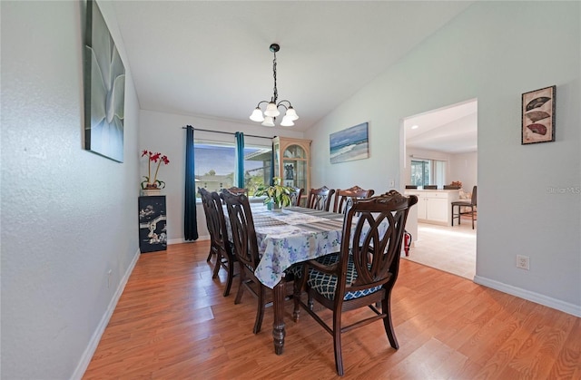 590 Ridgewood St NW, Port Charlotte, FL 33952 - dining space with a chandelier, light wood-style flooring, lofted ceiling, healthy amount of natural light, and baseboards