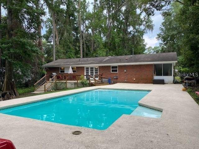 1616 NW 39th Ave, Gainesville, FL 32605 - swimming pool with a wooden deck, a patio, french doors, and stairway