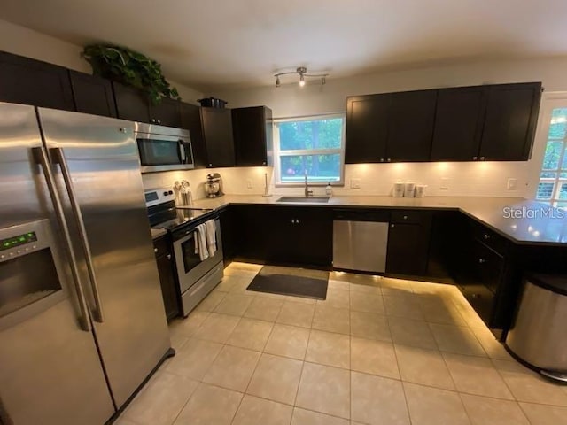 1616 NW 39th Ave, Gainesville, FL 32605 - kitchen featuring appliances with stainless steel finishes, plenty of natural light, dark cabinetry, and tasteful backsplash