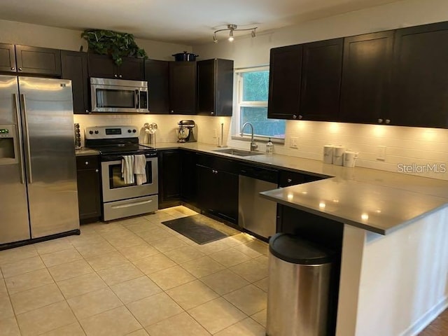1616 NW 39th Ave, Gainesville, FL 32605 - kitchen featuring appliances with stainless steel finishes, a peninsula, tasteful backsplash, and light countertops