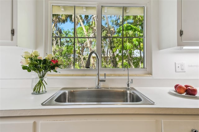 3001 Bay Shore Cir, Sarasota, FL 34234 - kitchen view of a sink, light countertops, and white cabinetry
