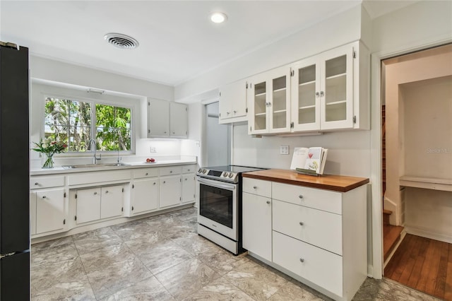 3001 Bay Shore Cir, Sarasota, FL 34234 - kitchen featuring stainless steel range with electric cooktop, a sink, freestanding refrigerator, glass insert cabinets, and white cabinets