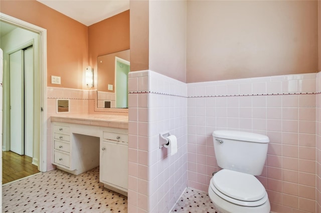 3001 Bay Shore Cir, Sarasota, FL 34234 - bathroom featuring tile walls, vanity, toilet, and wainscoting