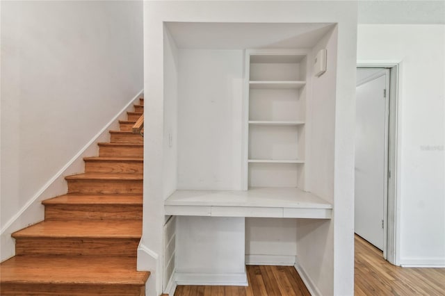 3001 Bay Shore Cir, Sarasota, FL 34234 - staircase featuring built in desk and wood finished floors