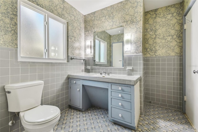 3001 Bay Shore Cir, Sarasota, FL 34234 - bathroom with tile walls, toilet, wallpapered walls, vanity, and a wainscoted wall