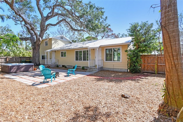 3001 Bay Shore Cir, Sarasota, FL 34234 - back of house with a hot tub, a patio area, and metal roof