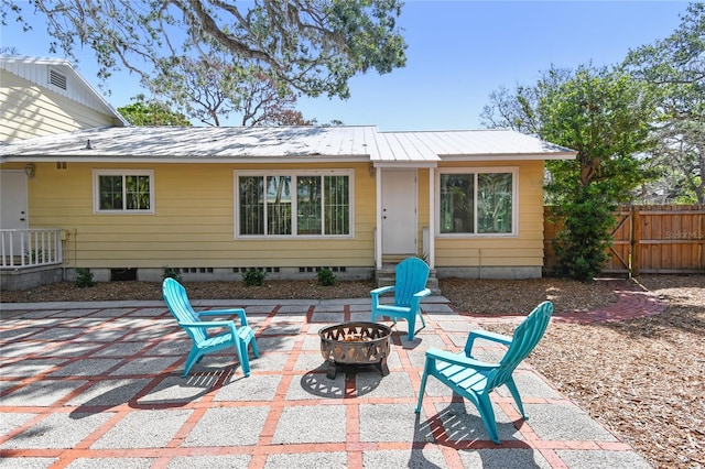 3001 Bay Shore Cir, Sarasota, FL 34234 - back of property featuring a fire pit, crawl space, a patio area, and metal roof