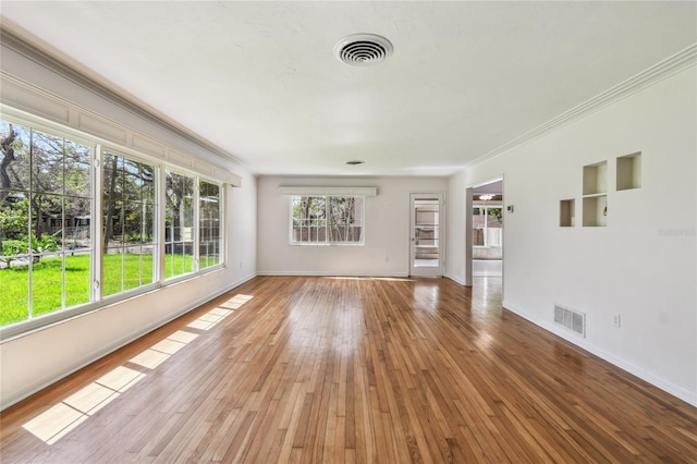 3001 Bay Shore Cir, Sarasota, FL 34234 - unfurnished living room featuring baseboards, hardwood / wood-style flooring, and crown molding