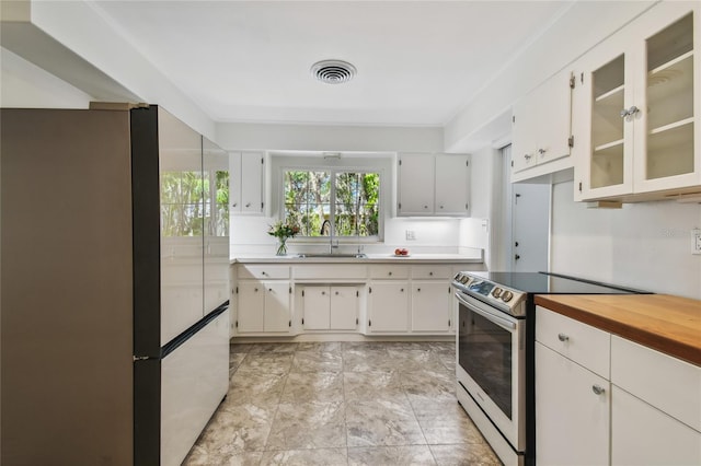 3001 Bay Shore Cir, Sarasota, FL 34234 - kitchen with high end refrigerator, electric range, a sink, light countertops, and glass insert cabinets